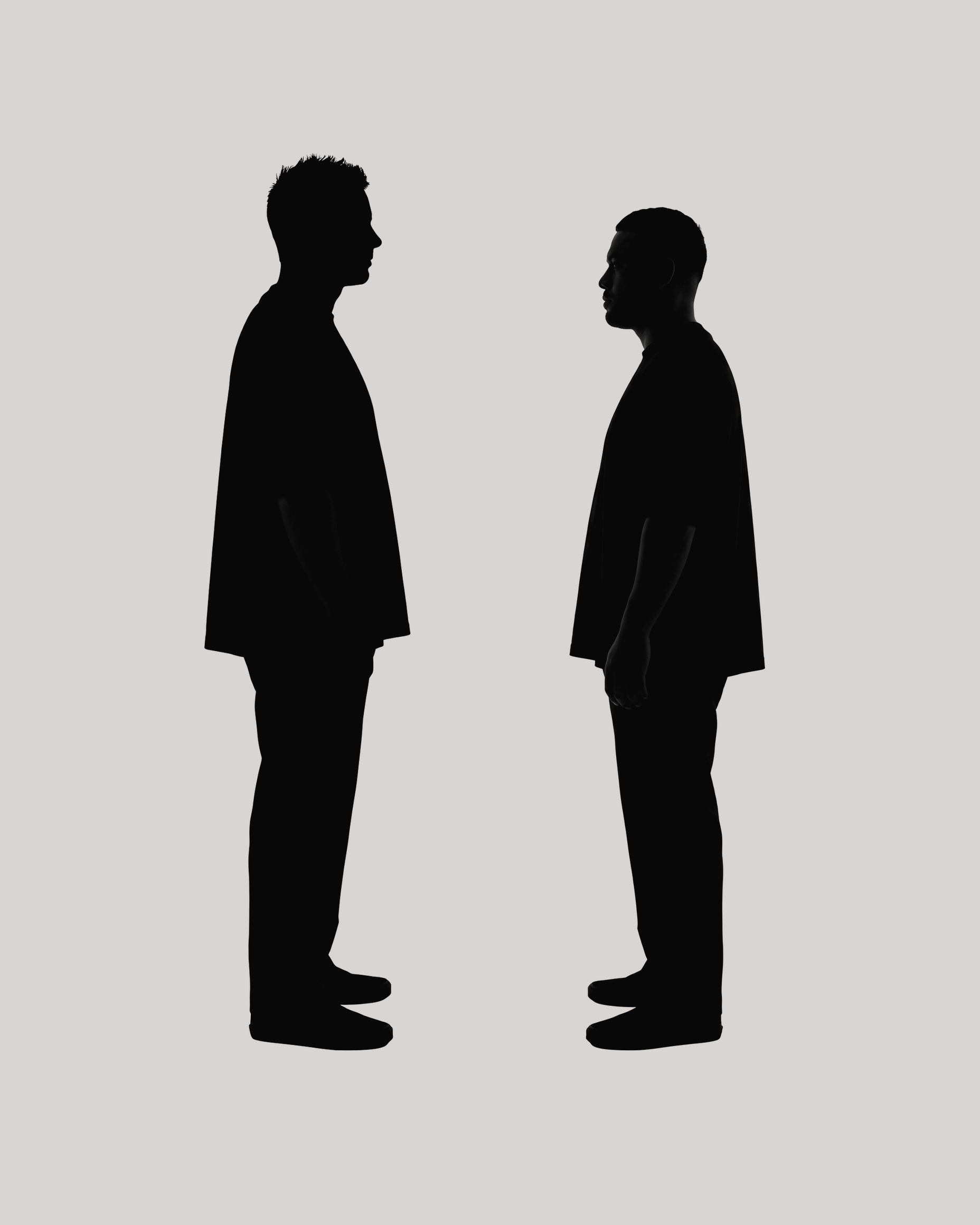 Dark silhouettes of Rich Tangney and Nic Haldezos standing in profile facing each other against a flat pale grey background.